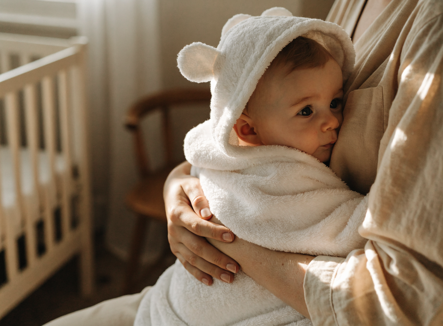 Bébé enveloppé dans une cape de bain blanche à capuche